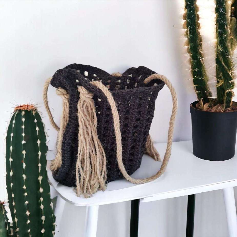 Sac ajouré crocheté en ficelle de jute de couleur noire avec une anse en corde de chanvre.