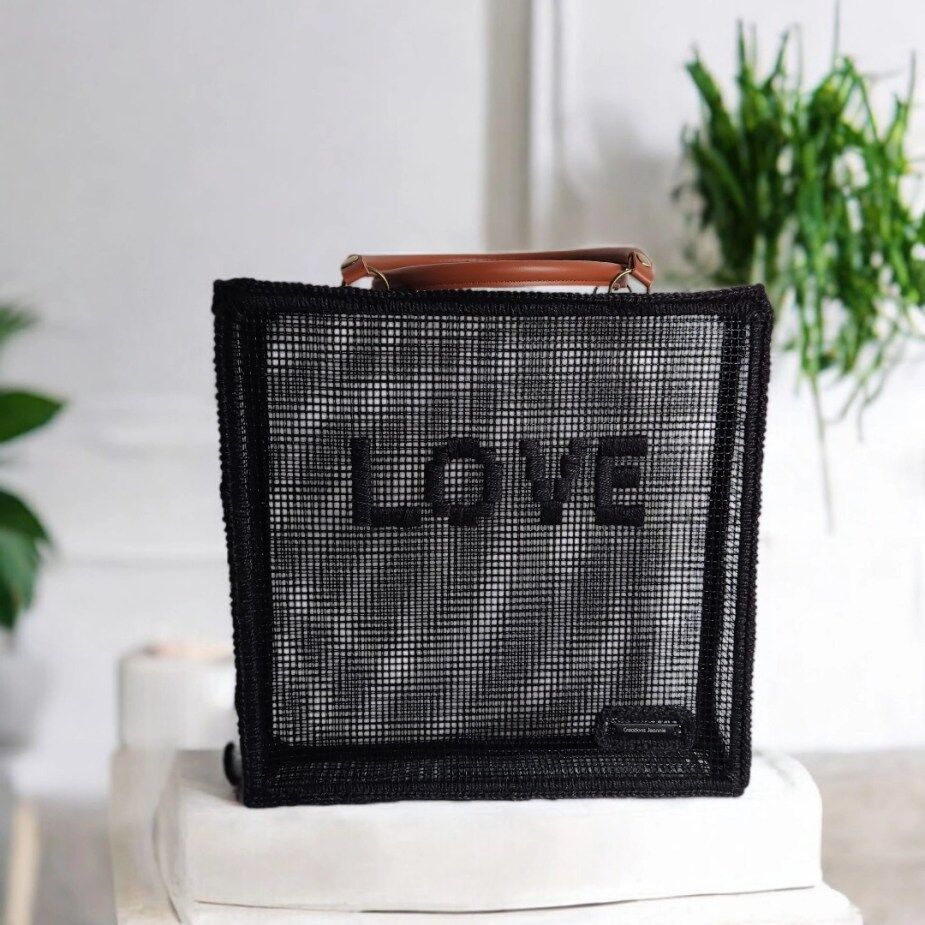 cabas de marché crocheté en ficelle de jute et grille polypropylène noires avec inscription LOVE brodé sur l'avant du sac et anses cuir marron camel